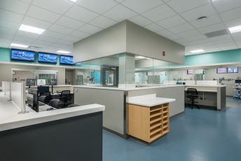 Modern hospital nurse station with monitors.
