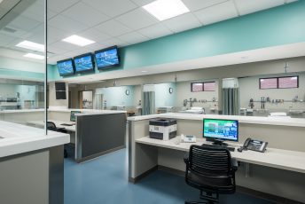 Hospital nurse station with computer and monitors.
