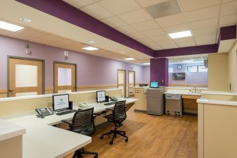 Hospital reception area with computers and chairs.