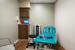 Physical therapy room with equipment and table.