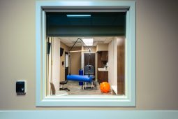 Physical therapy room with equipment and mirror.