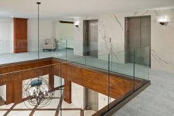 Modern lobby with elevators and glass railings.